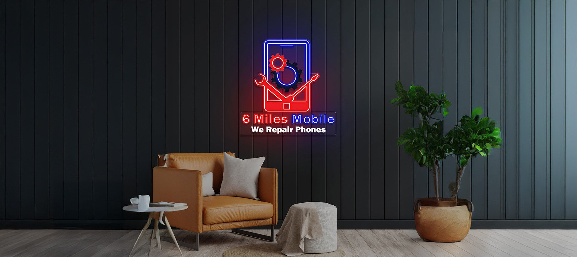 Neon sign on a dark wall with a chair and plant in the foreground