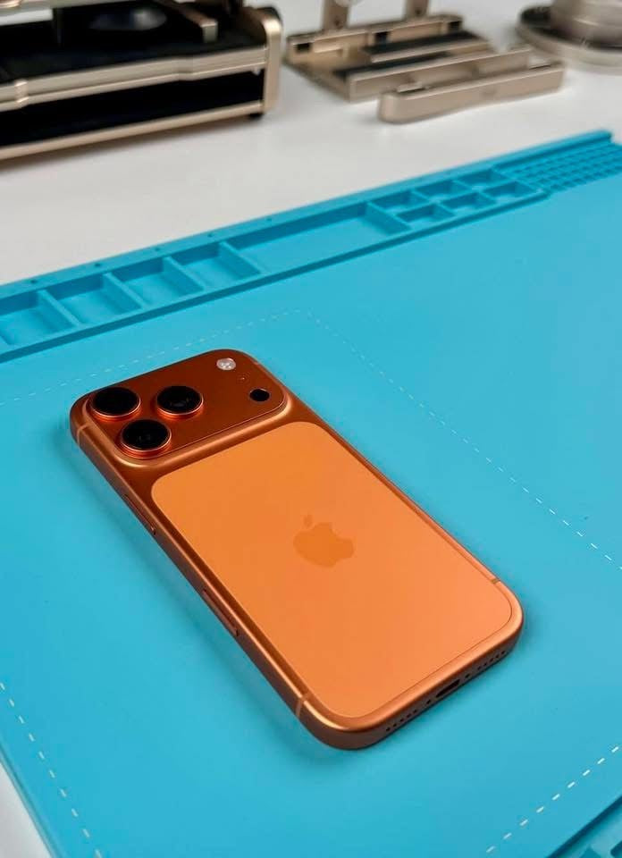 Orange iPhone on a blue mat with tools in the background