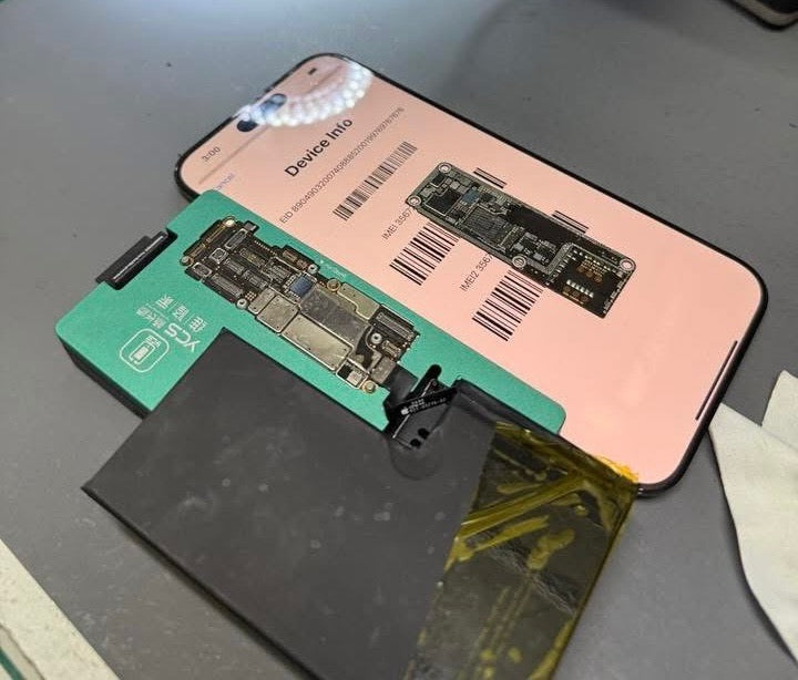 Phone with its back cover removed, revealing the internal components on a gray surface.