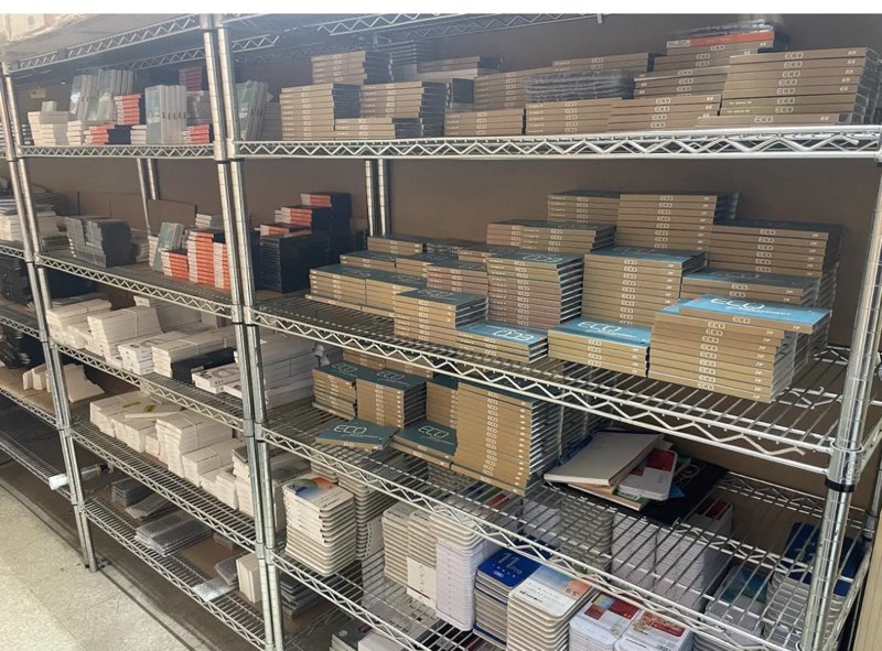 Metal shelving unit with stacked boxes and documents in a warehouse setting