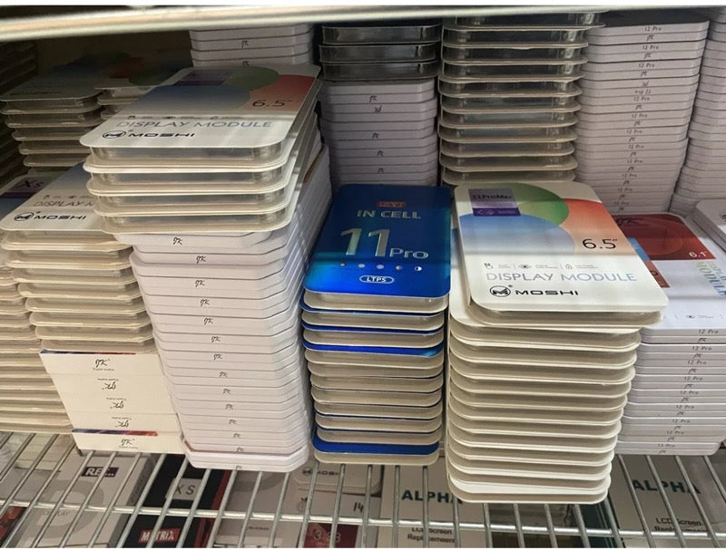 Stacks of phone screen replacement modules on a metal shelf